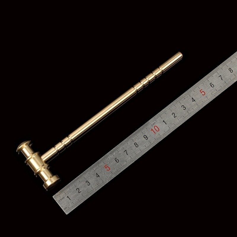 Mažas varinis plaktukas, daužantis graikinį riešutą, ranka žaidžiamas ornamentas laikrodis ir laikrodis, taisymas, mikro įrankių sauga