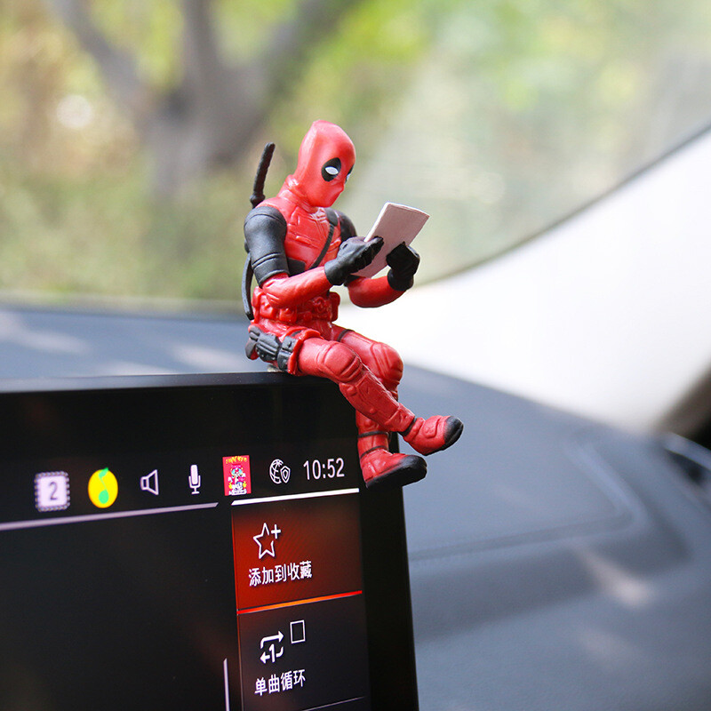 Deadpool sėdėjimas, skaitymo knyga, maža kalytės figūrėlė, stalinis kompiuteris, kūrybingas automobilis, galinio vaizdo veidrodėlis, centrinio valdymo papuošalai
