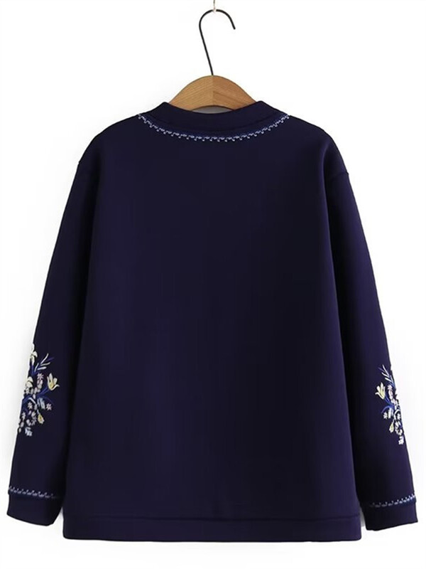 Suures suuruses naiste mantel, ümmargune kaelus, pikkade varrukatega paksendatud mantel, mille sees on plüüs, varrukatel tikitud lillemotiiv