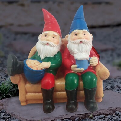 Dobar provod. Lijeni patuljci na kauču koji jedu čips i piju kip u vrtu s pivom