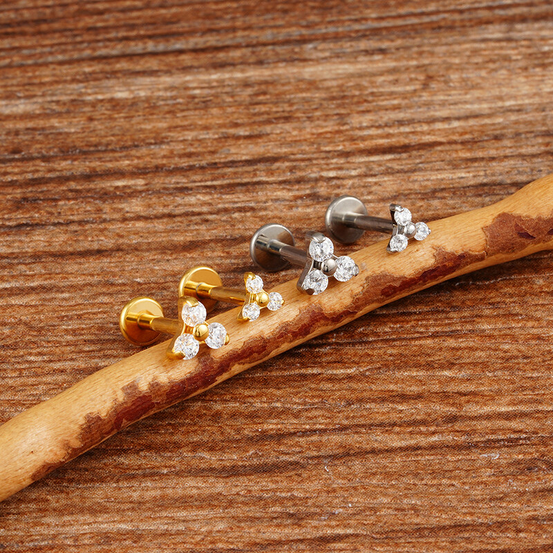 Piercing do pery s trojitým CZ náušnicou z titánu 16G s trojitým CZ náušnicou z tragusu a mušle.