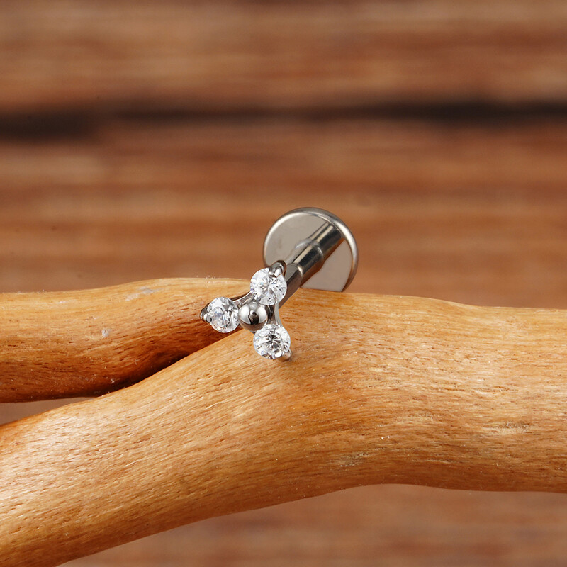 Piercing do pery s trojitým CZ náušnicou z titánu 16G s trojitým CZ náušnicou z tragusu a mušle.