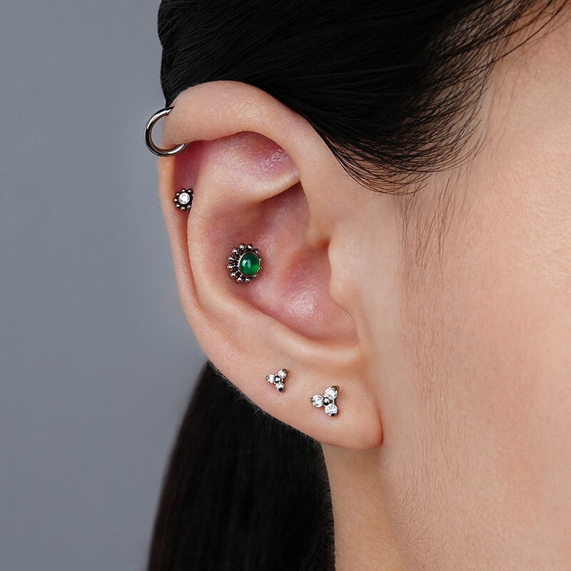 Piercing do pery s trojitým CZ náušnicou z titánu 16G s trojitým CZ náušnicou z tragusu a mušle.