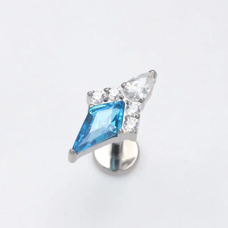 Piercing do ucha s diamantom, modrým a zlatým náušnicou, ASTM F136, titánové náušnice, chrupavka, špirála, tragus, lastúra, šperky.