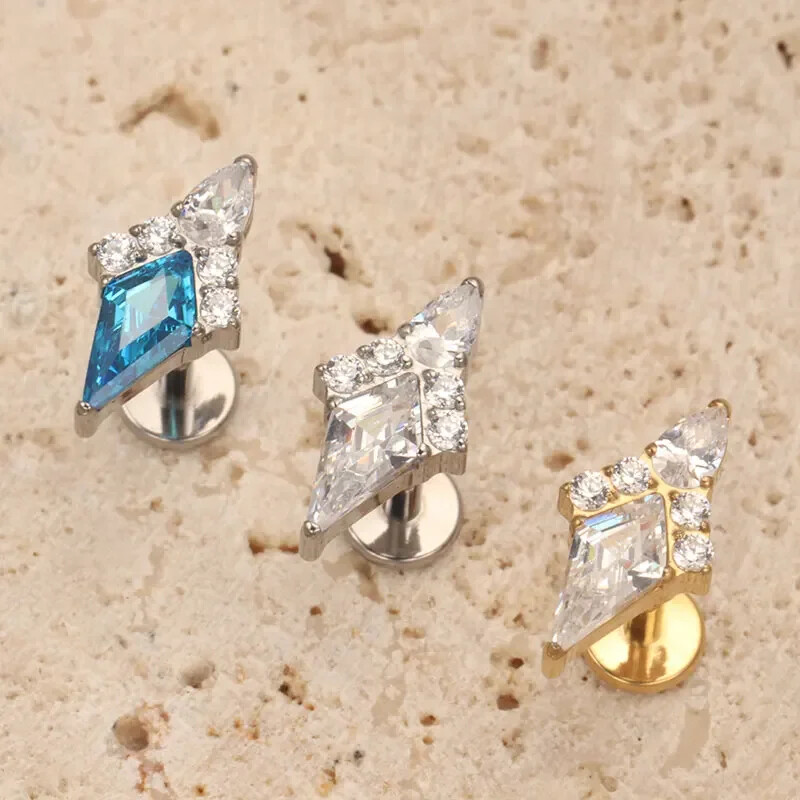 Piercing do ucha s diamantom, modrým a zlatým náušnicou, ASTM F136, titánové náušnice, chrupavka, špirála, tragus, lastúra, šperky.