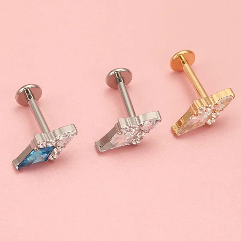 Piercing do ucha s diamantom, modrým a zlatým náušnicou, ASTM F136, titánové náušnice, chrupavka, špirála, tragus, lastúra, šperky.
