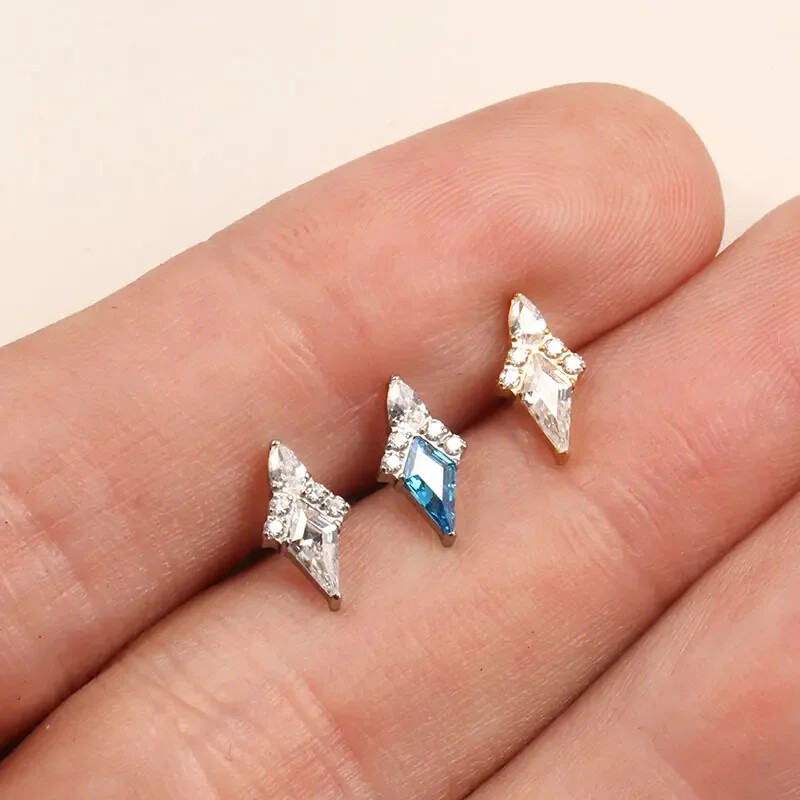 Piercing do ucha s diamantom, modrým a zlatým náušnicou, ASTM F136, titánové náušnice, chrupavka, špirála, tragus, lastúra, šperky.