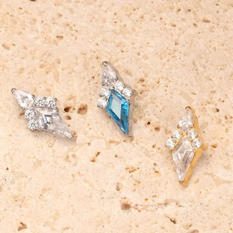 Piercing do ucha s diamantom, modrým a zlatým náušnicou, ASTM F136, titánové náušnice, chrupavka, špirála, tragus, lastúra, šperky.