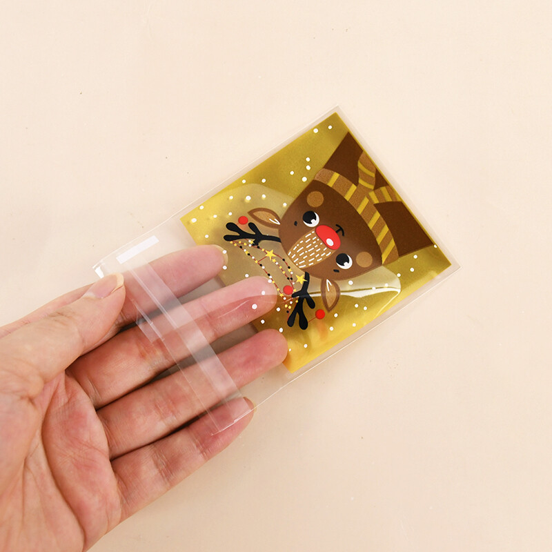 100gab Ziemassvētku konfekšu maisiņi Ziemassvētku vecīša sniegavīrs aļņa cepumu dāvanu plastmasas iepakojuma maisiņi 2025. gada Jaungada Ziemassvētku ballīšu rotājumi