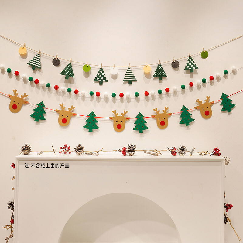 Нанизи от червени, зелени и бели помпони Коледни плюшени топки украсяват коледната елха и подреждат декорации около фона на окачената стена