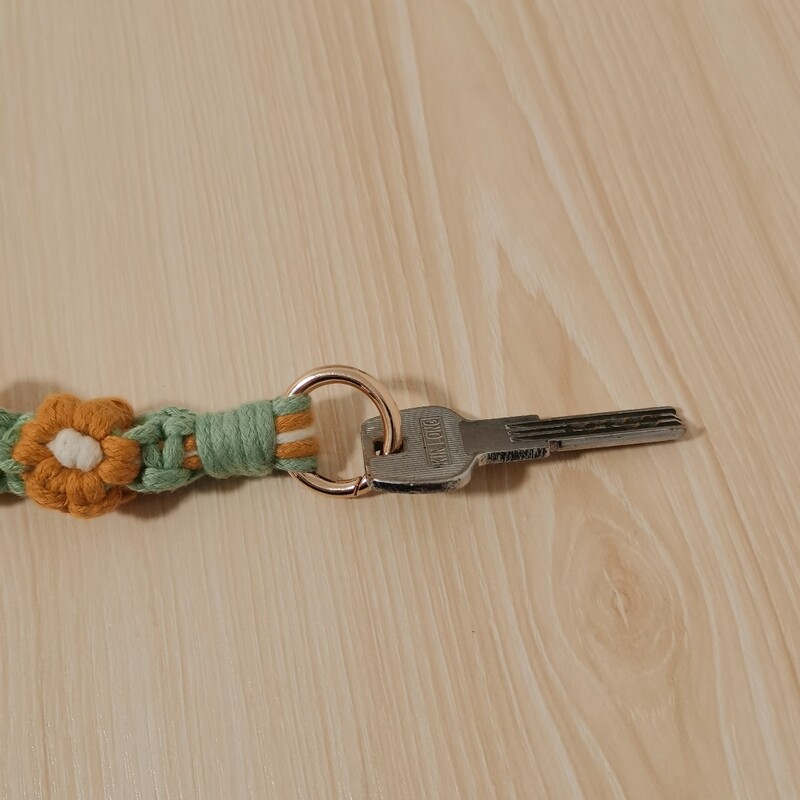 Ziedu margrietiņas kulonu atslēgu piekariņš, kas nēsāts uz plaukstas bohēmisks, ar rokām austs ziedu atslēgu piekariņa maisiņš, kulonu dekors