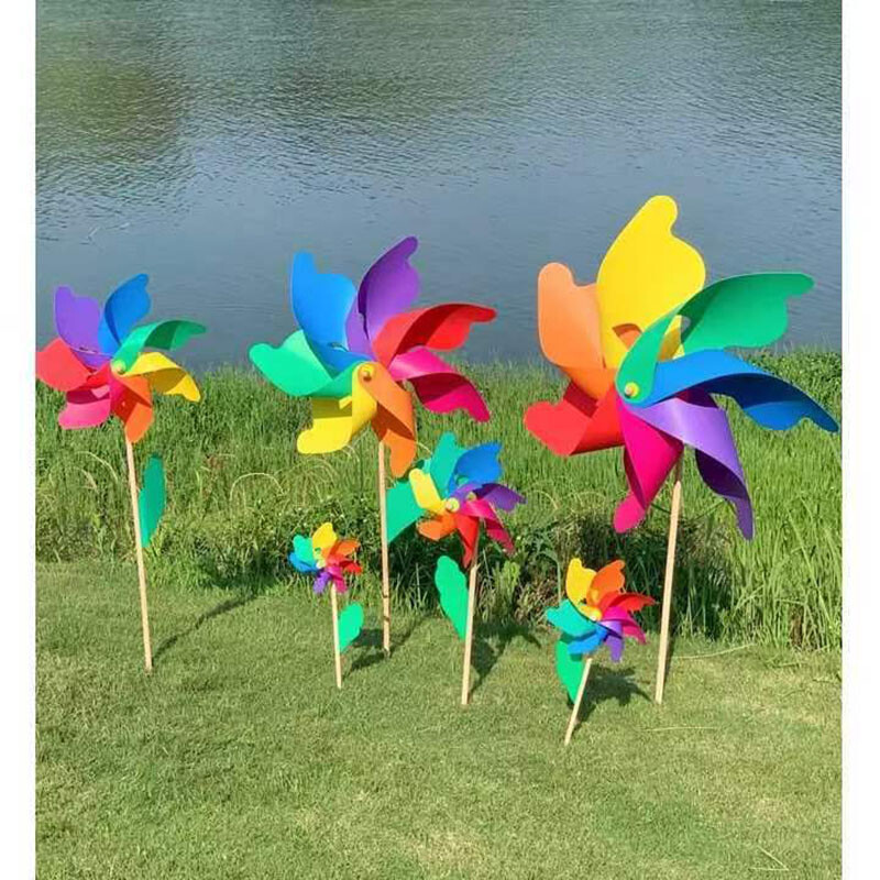 Spalvingo vėjo malūno lauko dekoravimo festivalio vaizdingas parkas, vaikai laiko besisukantį medinį spalvotą vėjo malūną