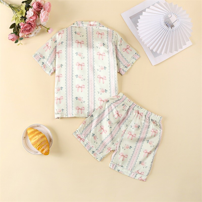 Zīdaiņu zīdaiņu meiteņu atpūtas apģērbs Vasaras mazuļu pidžamas komplekts bantītes ziedu raksta pogai ar īsām piedurknēm Topi Šorti Mazu bērnu mājas apģērbi