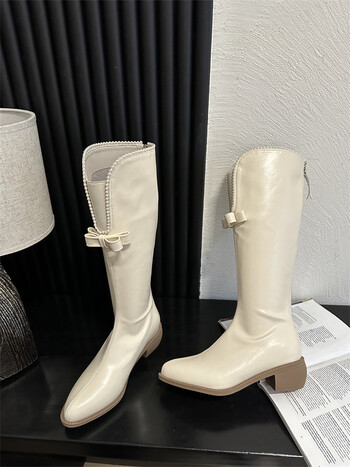 Liekninamieji aulinukai storais kulnais ir V formos iškirpte smulkaus sudėjimo moterims, riterio stiliaus aulinukai, ilgi balti „Chanel“ stiliaus aulinukai su perlų juostele moterims