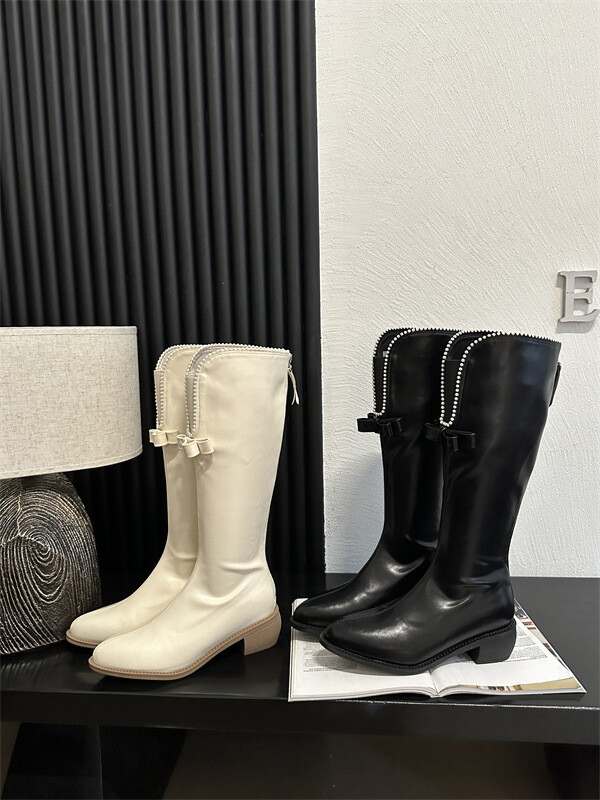 Liekninamieji aulinukai storais kulnais ir V formos iškirpte smulkaus sudėjimo moterims, riterio stiliaus aulinukai, ilgi balti „Chanel“ stiliaus aulinukai su perlų juostele moterims