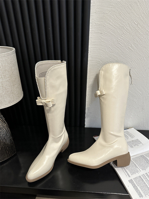 Liekninamieji aulinukai storais kulnais ir V formos iškirpte smulkaus sudėjimo moterims, riterio stiliaus aulinukai, ilgi balti „Chanel“ stiliaus aulinukai su perlų juostele moterims