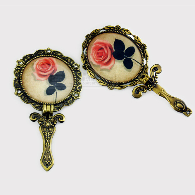 O oglindă mică portabilă cu mâner și motive de trandafiri în stil european, într-un stil vintage, perfectă pentru machiaj sau pentru ținute elegante. Un cadou minunat pentru îndrăgostiți sau pentru o zi de naștere.