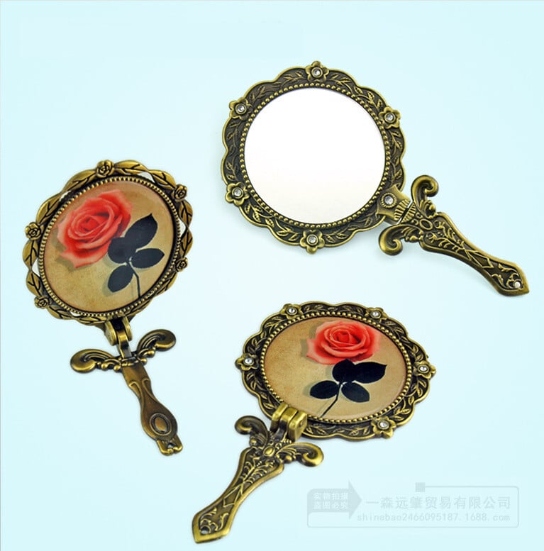 O oglindă mică portabilă cu mâner și motive de trandafiri în stil european, într-un stil vintage, perfectă pentru machiaj sau pentru ținute elegante. Un cadou minunat pentru îndrăgostiți sau pentru o zi de naștere.