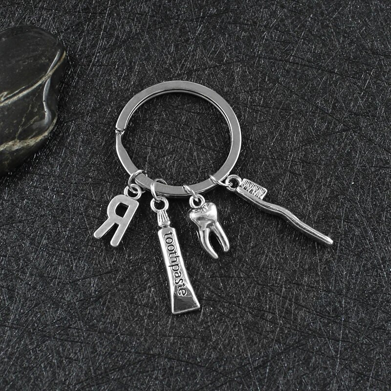 Radoša personība 26 vēstules ar zobu birstes zobu pastu Atslēgu piekariņš Zobi Veselības aizsardzības izpratne Piemiņas rotaslietas