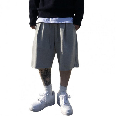 Muške kratke hlače s elastičnim strukom Elegantne muške kratke hlače s elastičnom vezom u struku, širokim dizajnom nogavica, džepovima za fitness