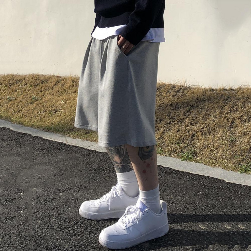 Muške kratke hlače s elastičnim strukom Elegantne muške kratke hlače s elastičnom vezom u struku, širokim dizajnom nogavica, džepovima za fitness