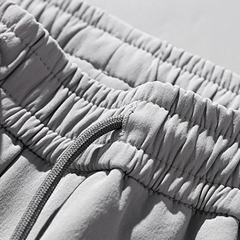 Augstas kvalitātes poliestera ledus zīda šorti vīriešiem 2024. gada jauna korejiešu versija ar vaļīgām elastīgām pludmalēm, piecu minūšu vidējas bikses